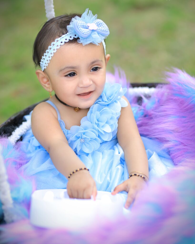 Serene baby dressed as a purple princess in a beautifully styled setting